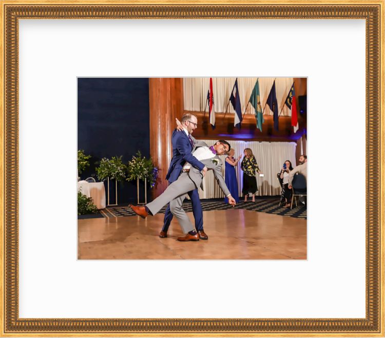 Two men dancing at wedding in a gold frame